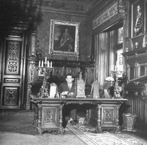 King Michael of Rumania sitting at his desk.