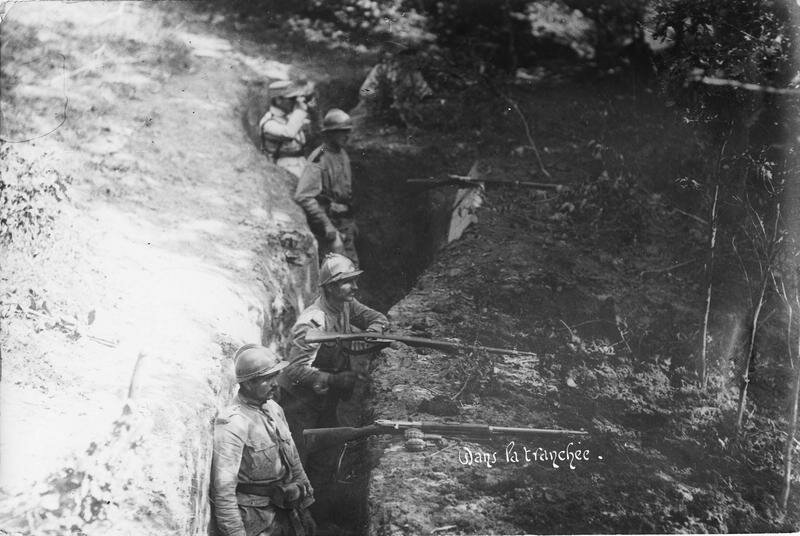 Soldier in a trench with their rifles resting on the parapet