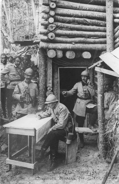 The Chief of Staff of the division giving orders by studying the map, the operator on the right